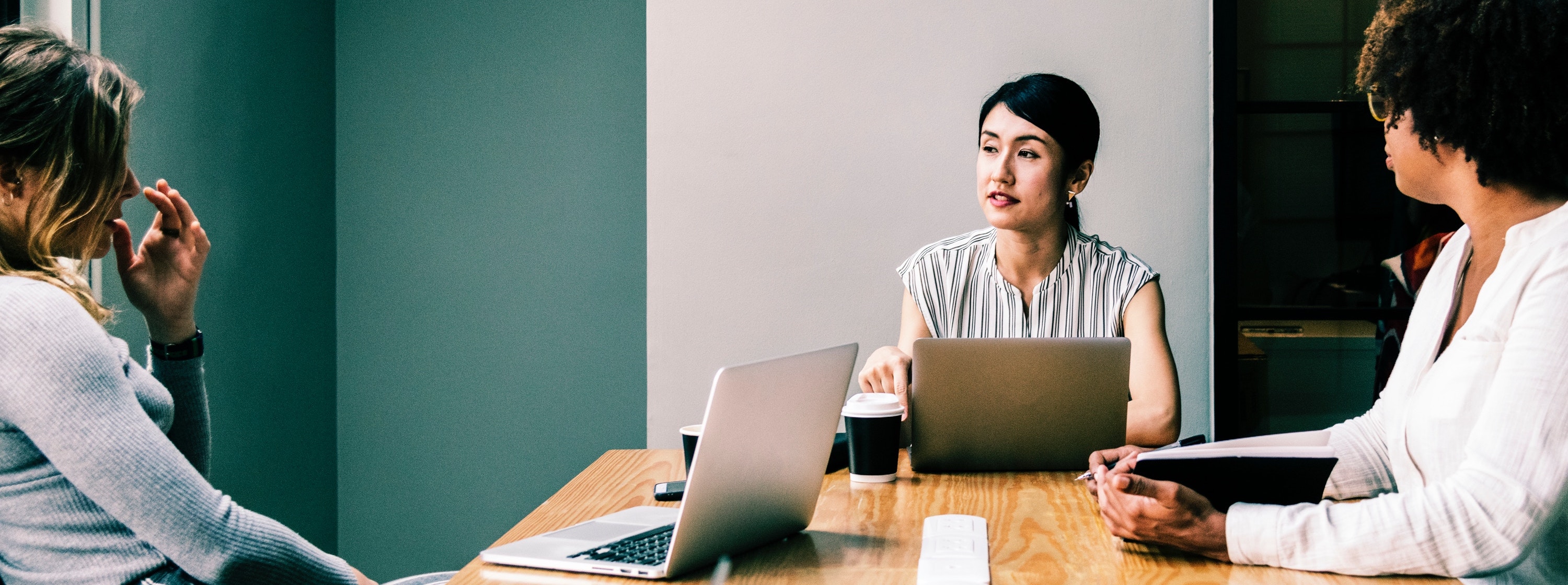 three recruiters with laptops at a meeting