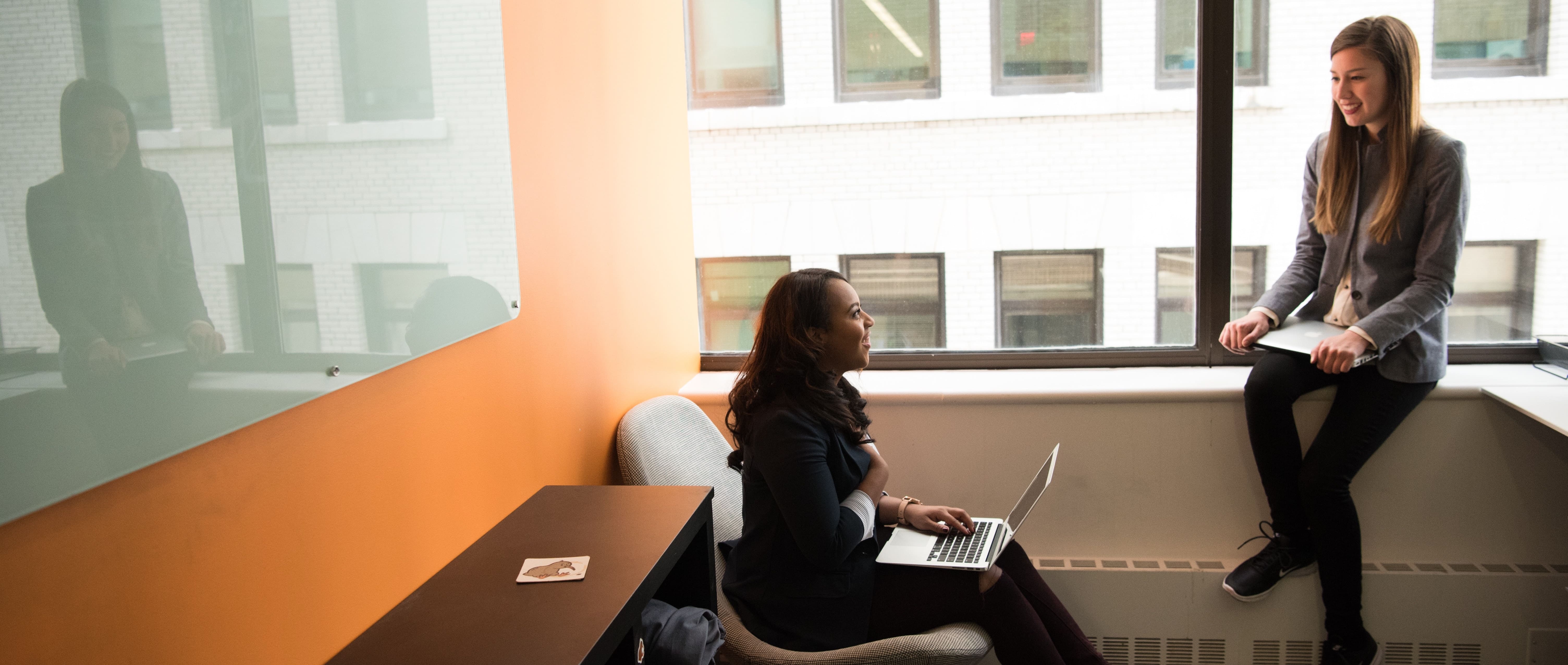 two women seated in an office discussing work