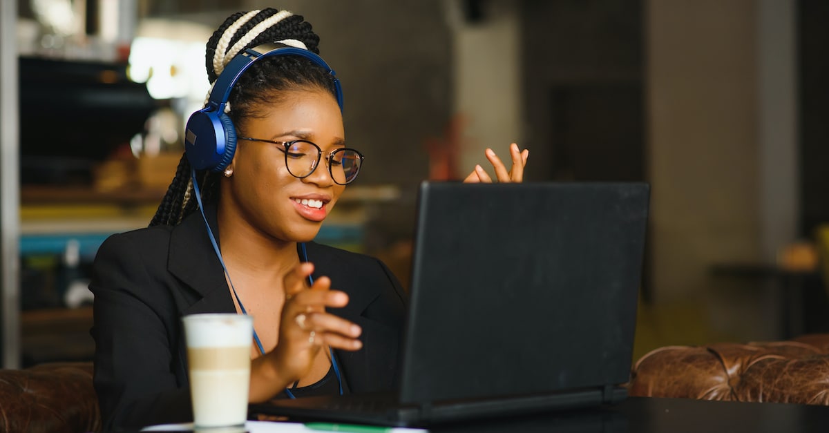 Happy,black,girl,in,wireless,headphones,studying,online,,using,laptop